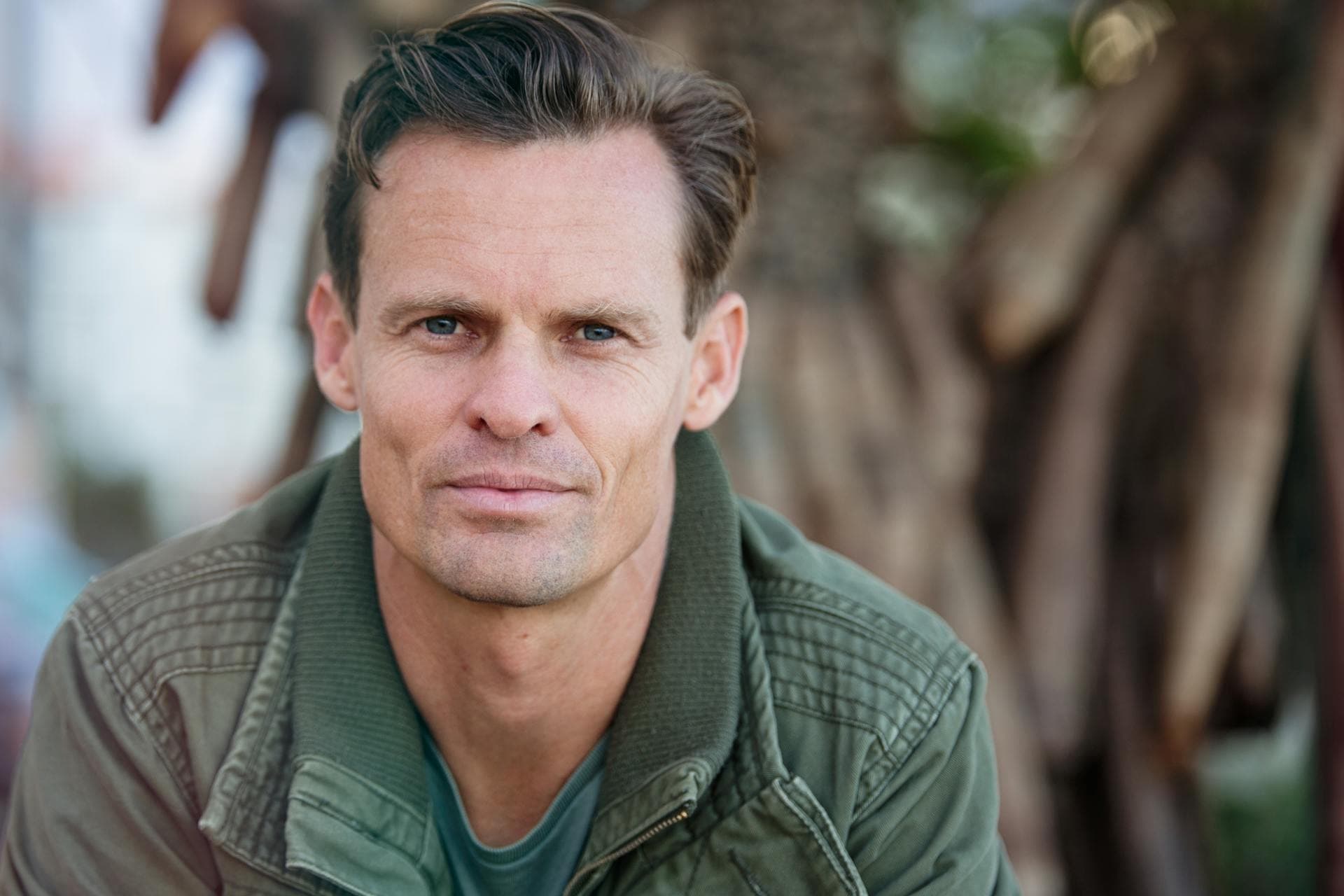 Man with slight smile in outdoor setting